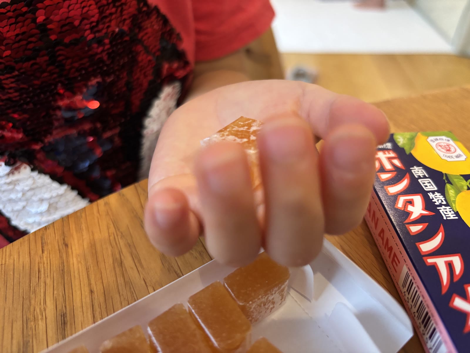 A single cube of Botan Ame held up close